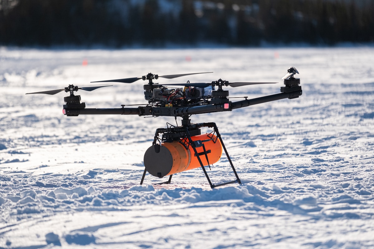 A remote controlled helicopter flying over a snow covered field