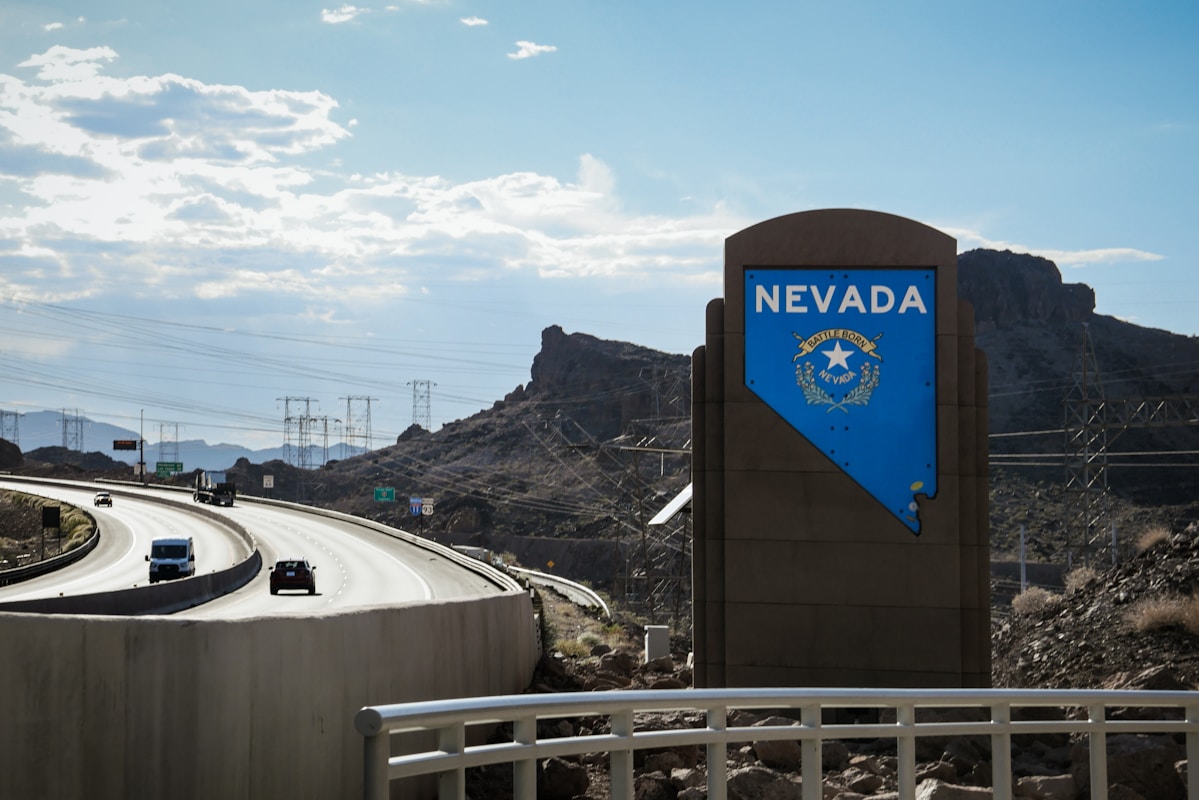 Photo by Lennon Kong a highway with a sign that says nevada on it