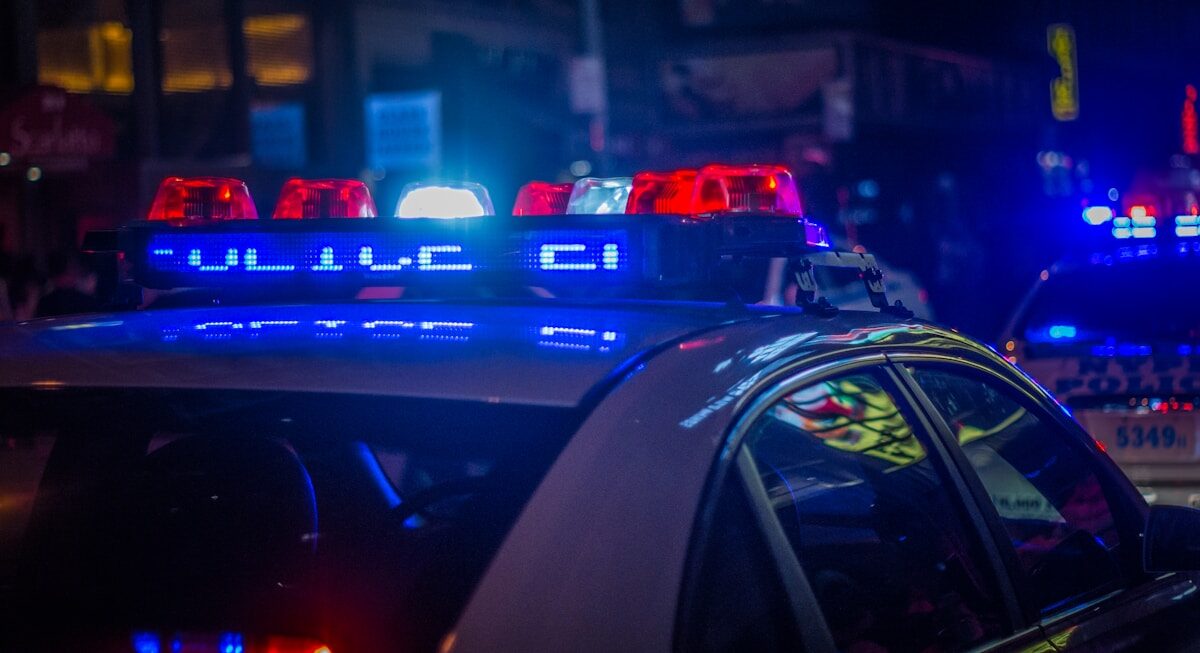 Police blue car on the street during night time