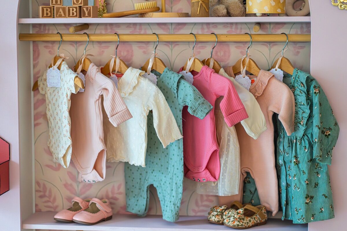 Baby Clothes Baby clothes hanging on a rack with shoes below shoes